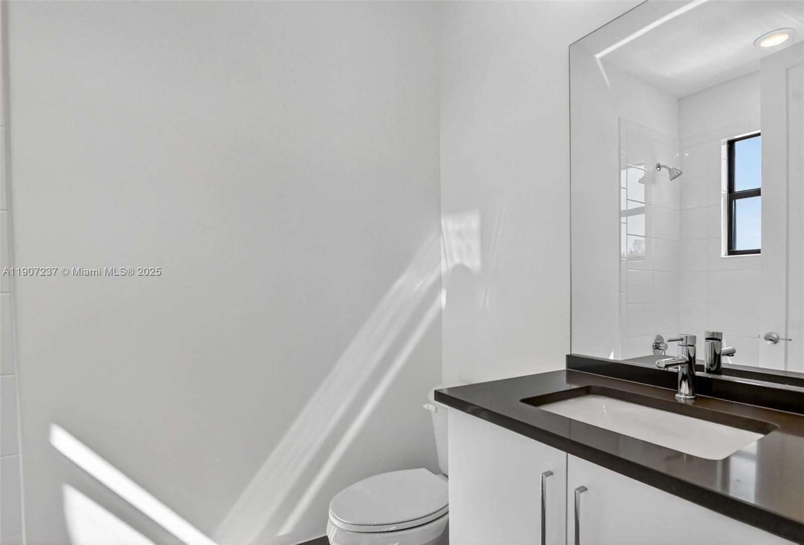 8215 Crystal Downs Avenue, Unit 8215 Boca Raton, FL 33434 - Photo 50 of 95 a bathroom with a granite countertop sink and a toilet