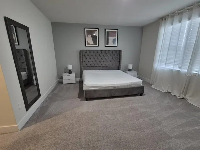 a spacious bedroom with a bed and a window