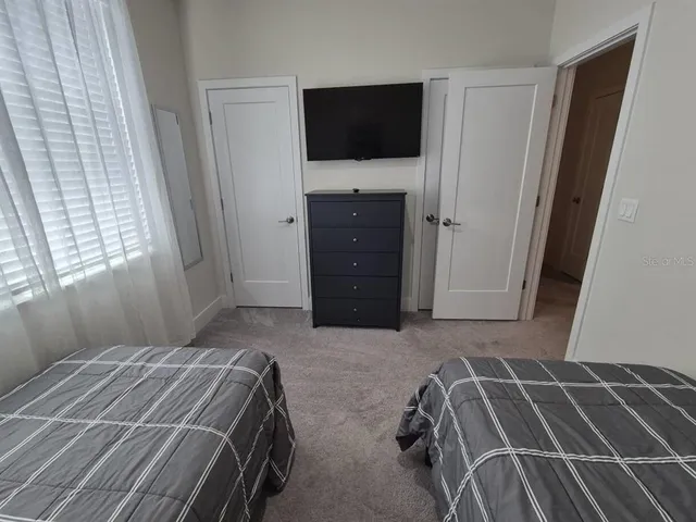 a bedroom with a bed and a flat screen tv