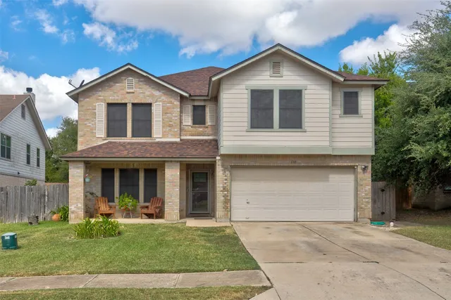 a front view of a house with a yard and garage