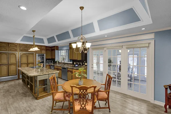 a dining room with furniture a chandelier and wooden floor