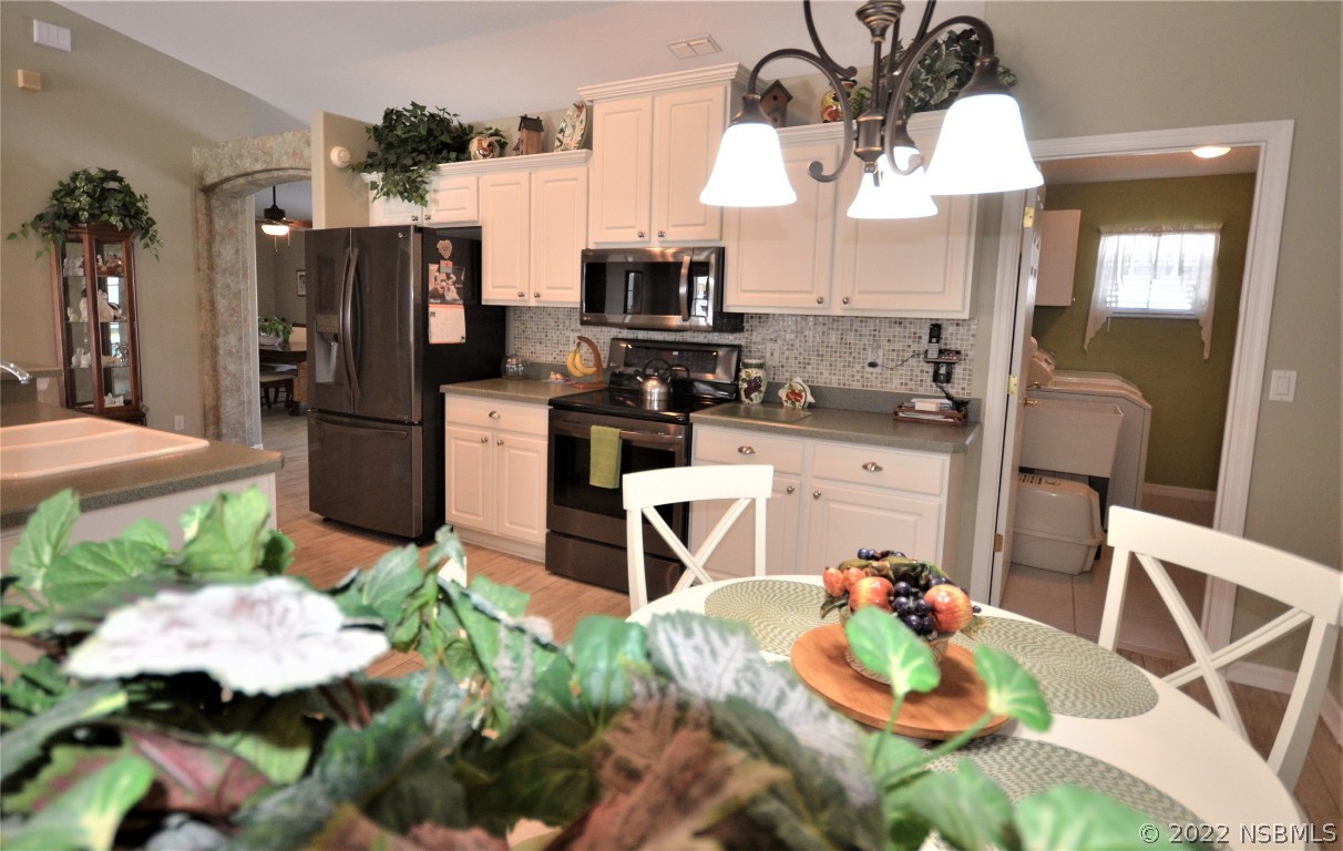 2924 Royal Palm Drive Edgewater, FL 32141 - Photo 26 of 43 a kitchen with stainless steel appliances kitchen island granite countertop a refrigerator and microwave