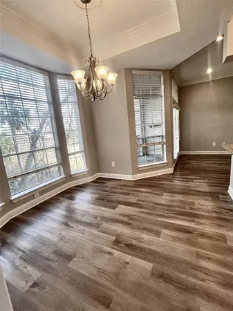 a view of an empty room with a window and chandelier