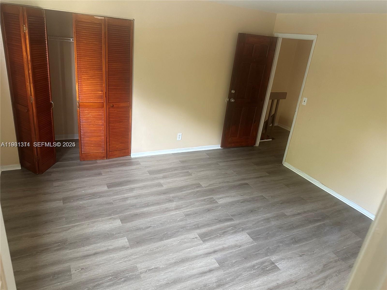 948 Southwest 74th Avenue North Lauderdale, FL 33068 - Photo 6 of 10 an empty room with wooden floor and closet