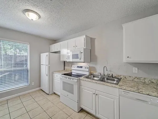a kitchen with white cabinets and white appliances