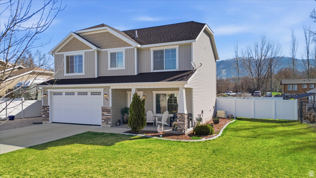 1084 South 740 East Logan, UT 84321 - Photo 22 of 23 Craftsman inspired home featuring covered porch, a garage, driveway, and stone siding