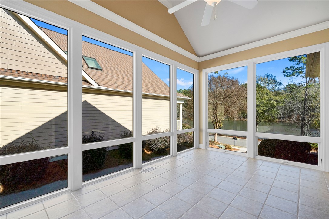 16 Oleander Drive Anderson, SC 29621 - Photo 18 of 37 A tranquil sunroom featuring vast windows, a vaulted ceiling, and a cooling fan for serene relaxation.