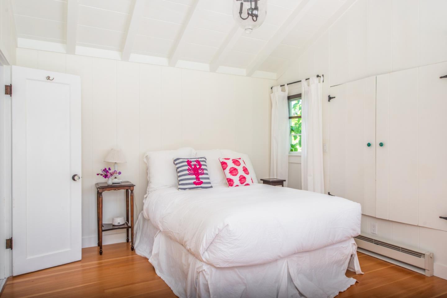 8990 West Carmel Valley Road Carmel Valley, CA 93923 - Photo 31 of 50 a bedroom with a bed and a white cabinet