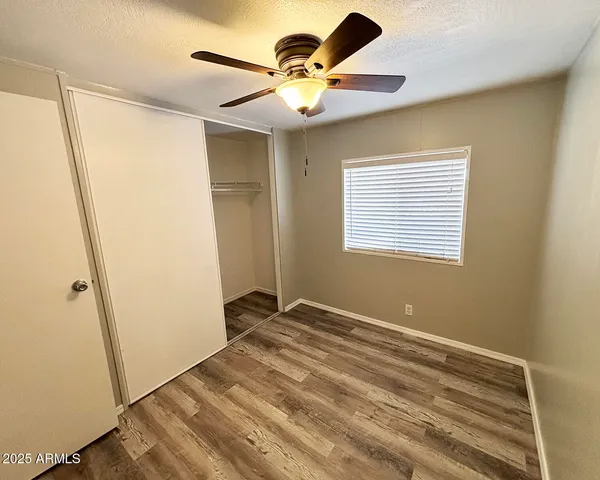 a view of an empty room and window and a ceiling fan