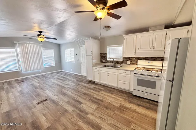 a view of empty room with wooden floor and ceiling fan