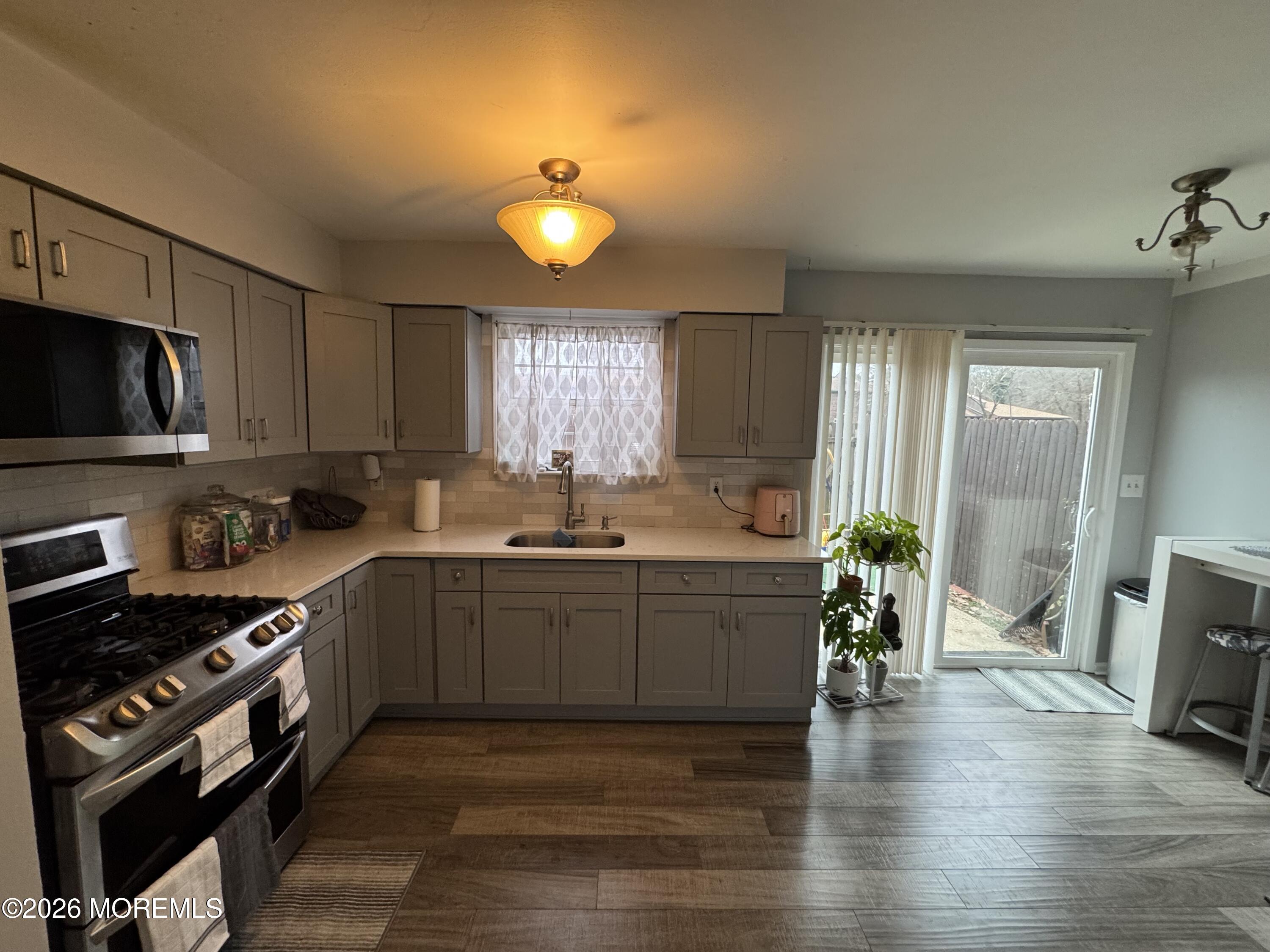 112 Greenwood Loop Road Brick, NJ 08724 - Photo 2 of 14 a large kitchen with cabinets wooden floor and stainless steel appliances