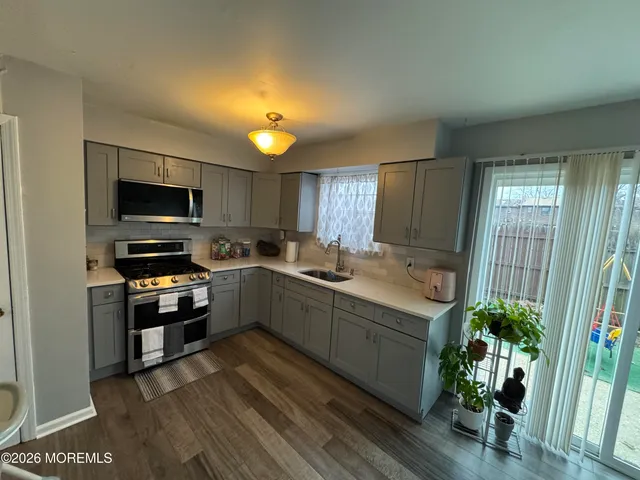 a kitchen with kitchen island granite countertop stainless steel appliances stove a sink and a microwave