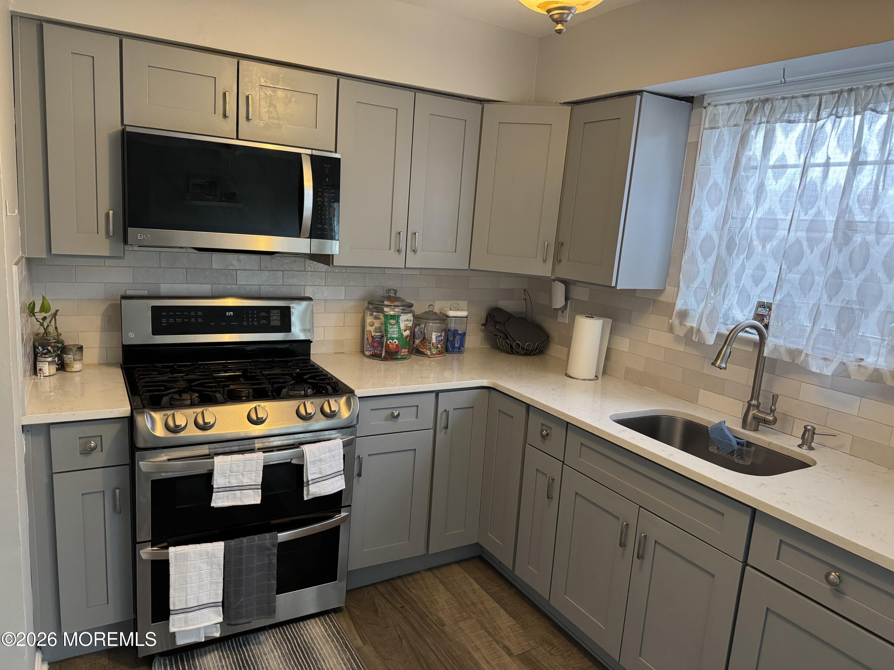 112 Greenwood Loop Road Brick, NJ 08724 - Photo 4 of 14 a kitchen with stainless steel appliances a stove a microwave and sink