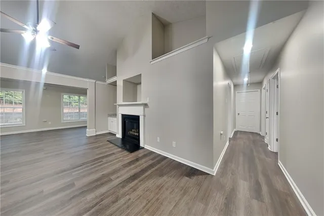 a view of a livingroom with wooden floor and a ceiling fan