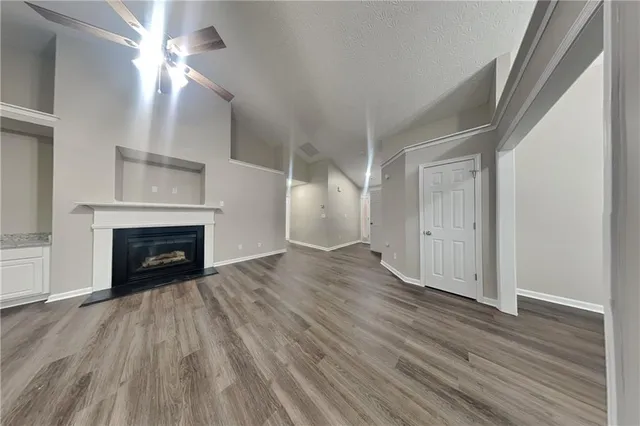 wooden floor fireplace and windows in an empty room