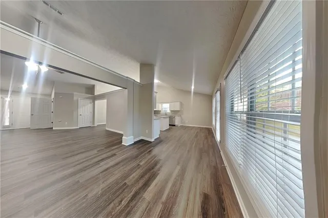 a view of empty room with wooden floor