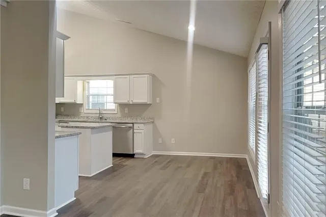 a kitchen with a white cabinets and wooden floor