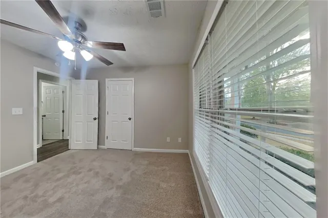 a view of a livingroom with a ceiling fan and window