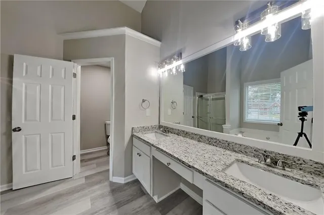 a bathroom with a granite countertop double vanity sink and a mirror