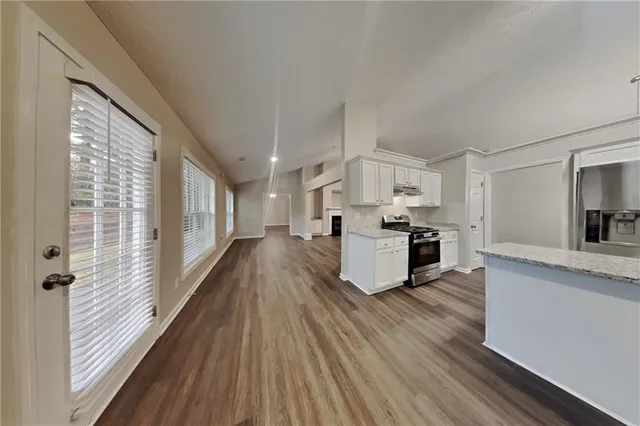 a kitchen with granite countertop a stove top oven and cabinets