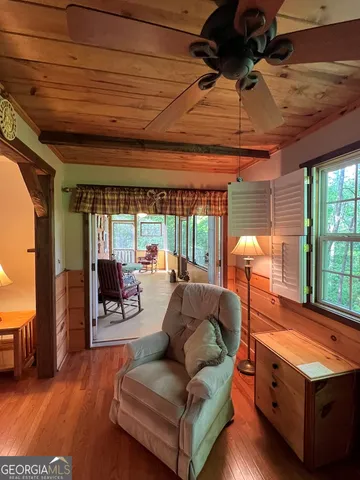 a living room with furniture a flat screen tv and a large window