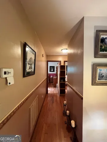 a view of a hallway and a livingroom with furniture