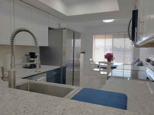 a kitchen with stainless steel appliances granite countertop a sink a stove and a refrigerator