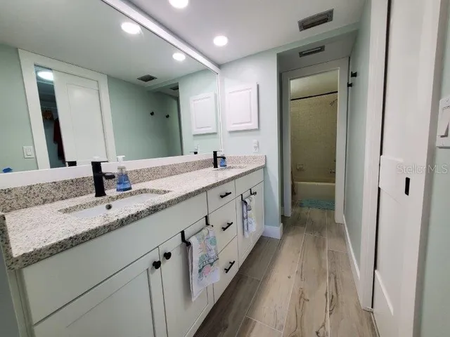 a bathroom with double sink and a mirror