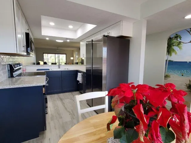 a kitchen with stainless steel appliances kitchen island granite countertop a refrigerator and a sink