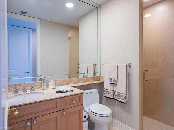 a bathroom with a granite countertop sink a toilet and shower