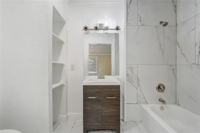 a large white kitchen with a lot of counter space and a sink