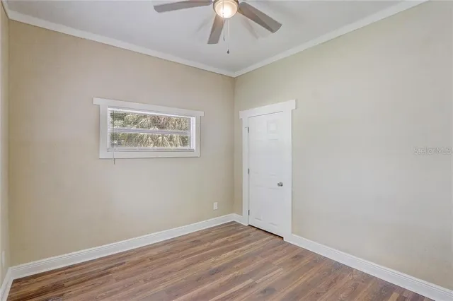 a view of an empty room with wooden floor
