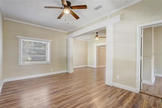 a view of a livingroom with a fireplace wooden floor and windows