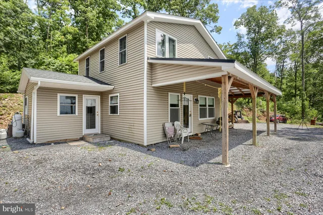 a view of a house with a yard and large tree