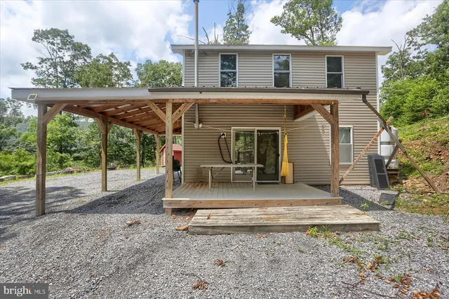 a view of a house with a yard and large tree