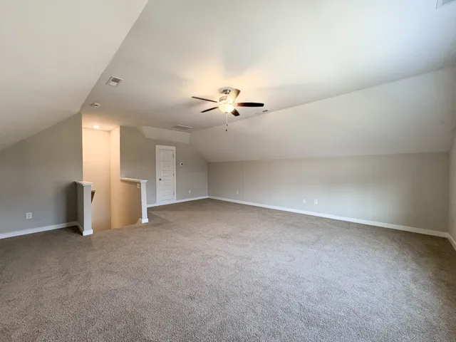 an empty room with a ceiling fan and window