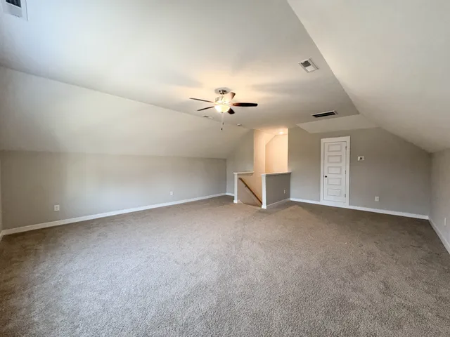 an empty room with a ceiling fan and window