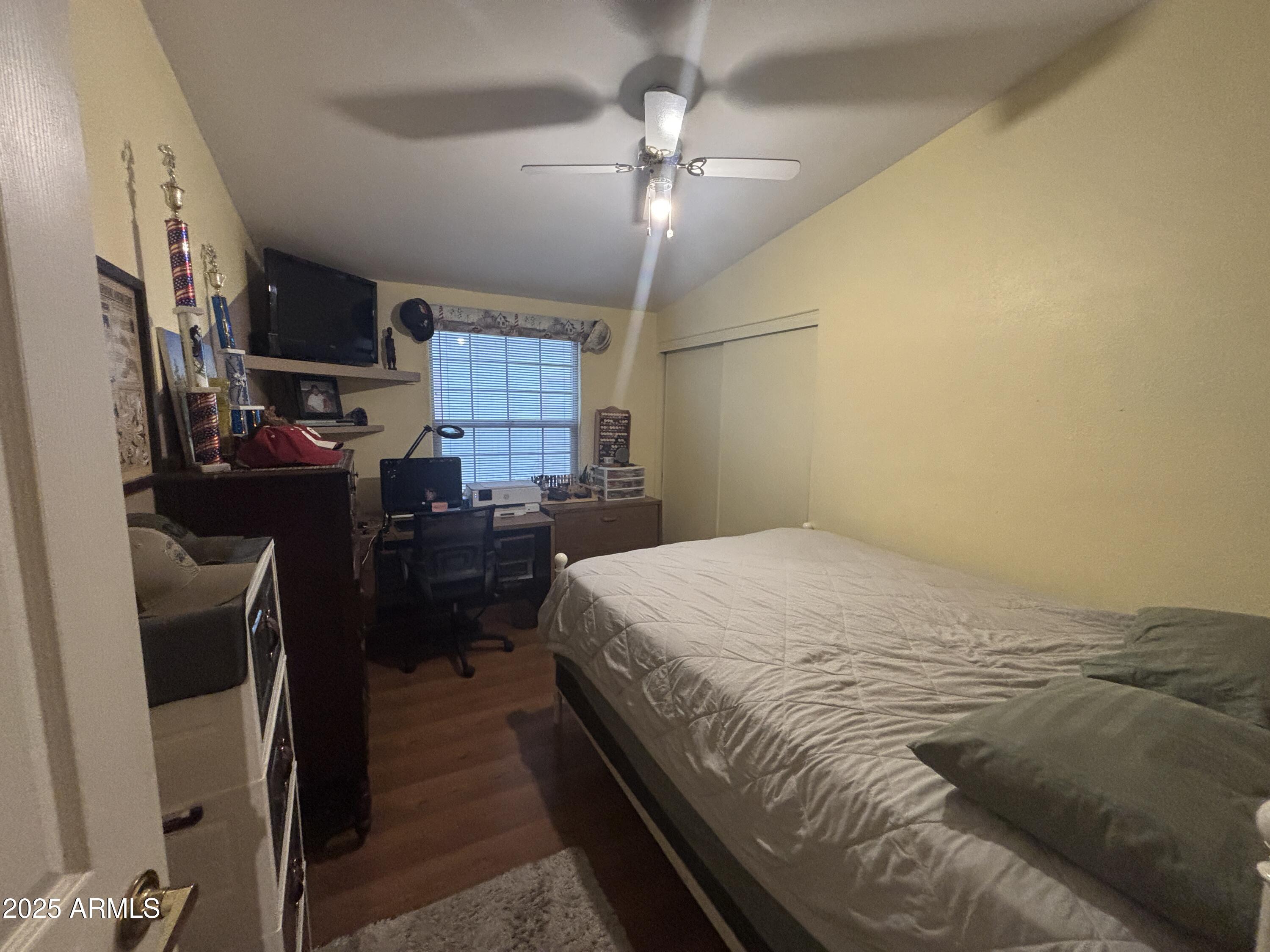 3500 South Tomahawk Road, Unit 153 Apache Junction, AZ 85119 - Photo 16 of 28 a bedroom with a bed dresser and a chandelier