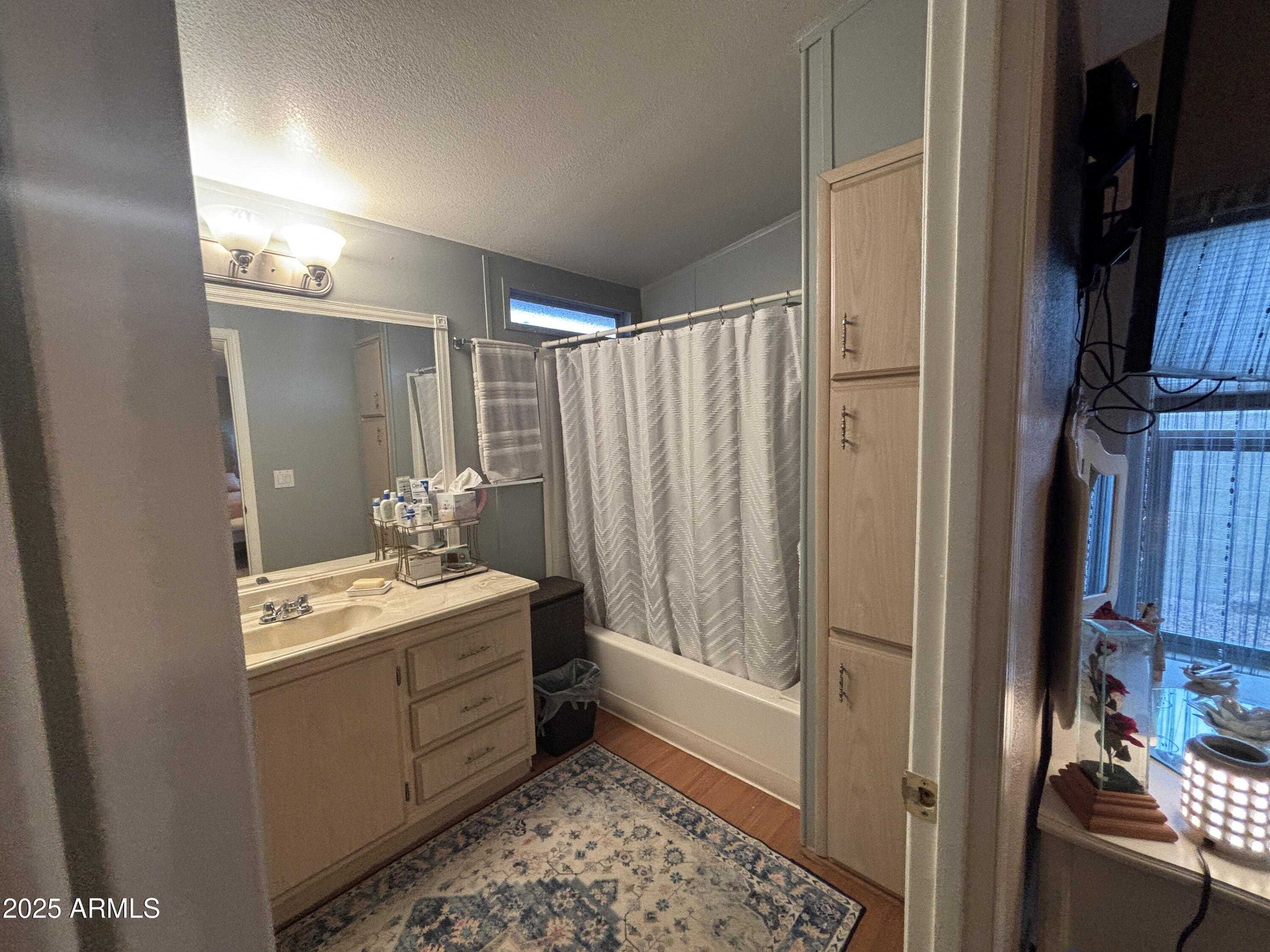 3500 South Tomahawk Road, Unit 153 Apache Junction, AZ 85119 - Photo 21 of 28 a bathroom with a sink a mirror and a shower