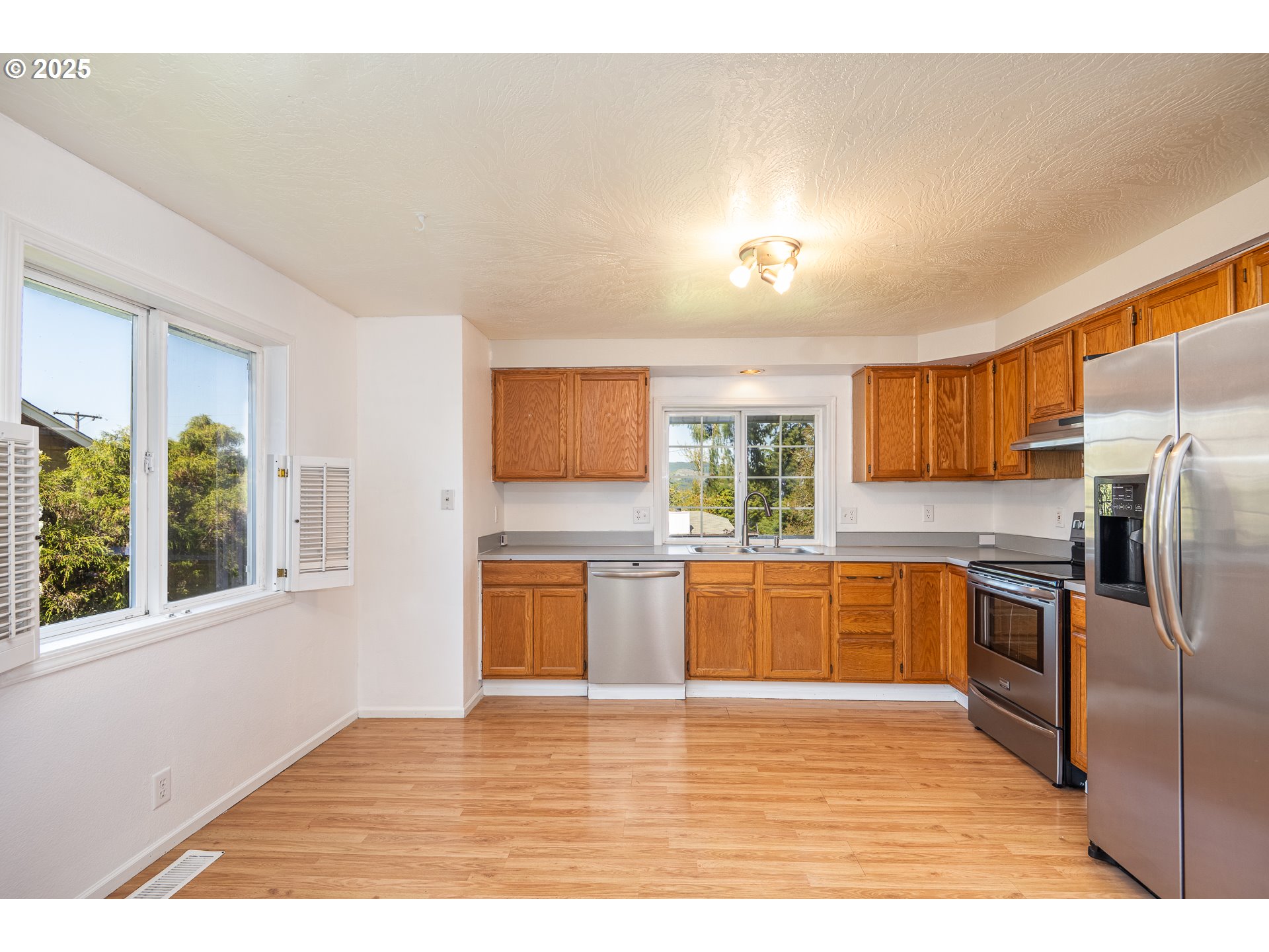 7015 South E Street Springfield, OR 97478 - Photo 8 of 22 a kitchen with stainless steel appliances granite countertop a refrigerator sink and stove