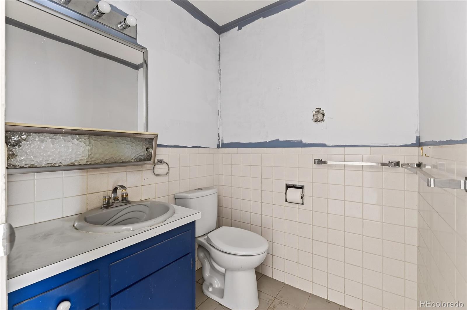 6795 West 31st Avenue Wheat Ridge, CO 80214 - Photo 12 of 35 a bathroom with a sink a toilet and mirror