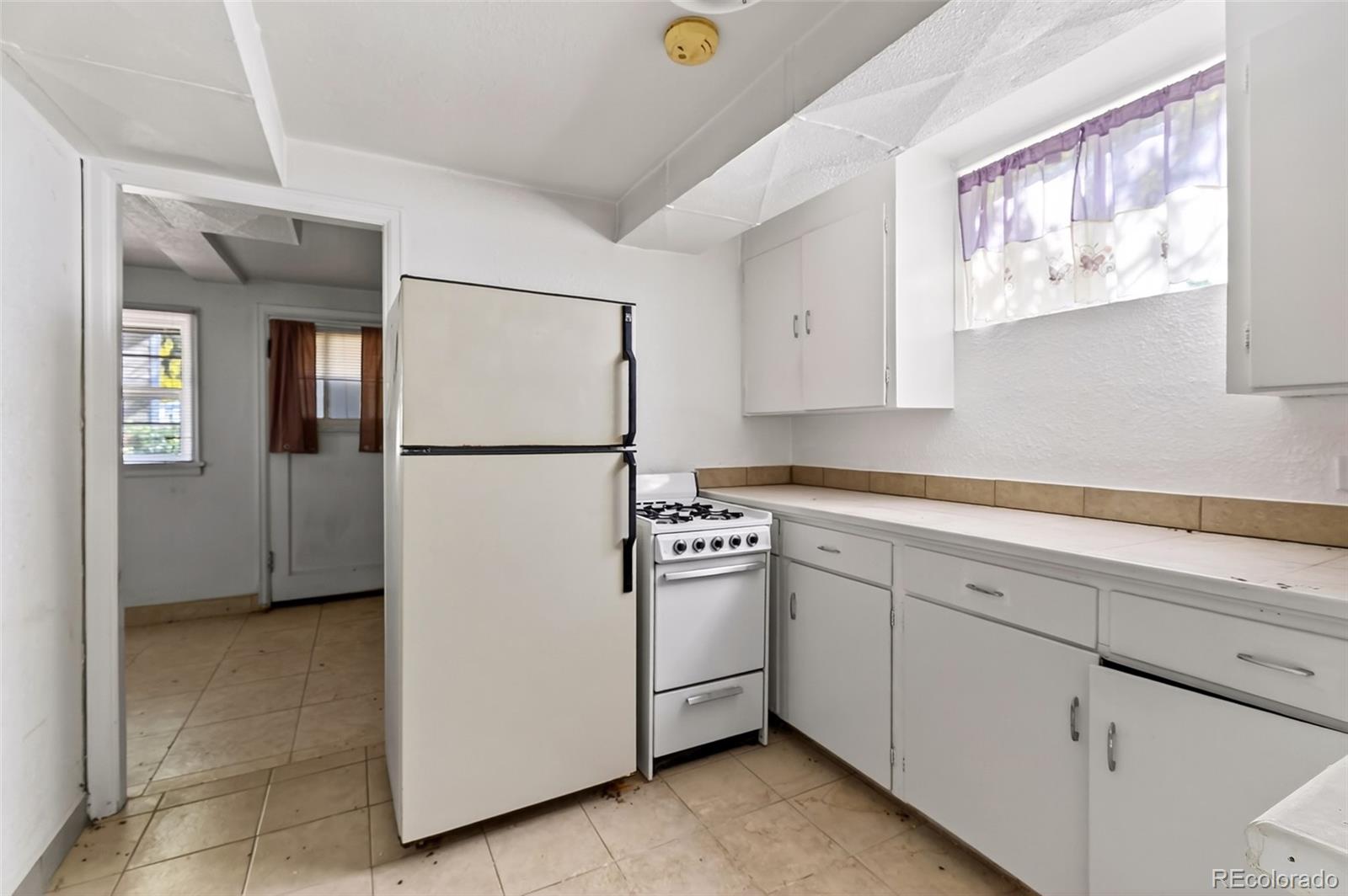 6795 West 31st Avenue Wheat Ridge, CO 80214 - Photo 15 of 35 a kitchen with a refrigerator and a sink