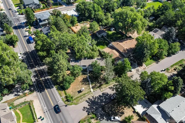an aerial view of residential house with outdoor space and trees all around
