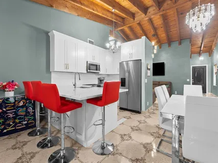 a kitchen with stainless steel appliances kitchen island granite countertop a refrigerator a stove a sink dishwasher with a dining table and chairs