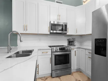 a kitchen with stainless steel appliances granite countertop white cabinets a sink and dishwasher
