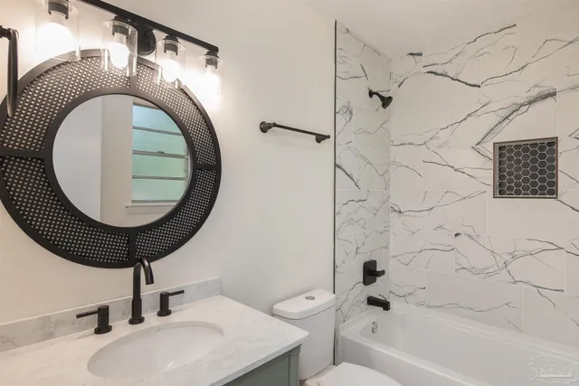 a bathroom with a sink a toilet and a mirror