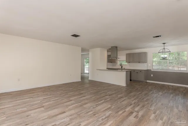 a view of a kitchen with a sink and dishwasher with wooden floor