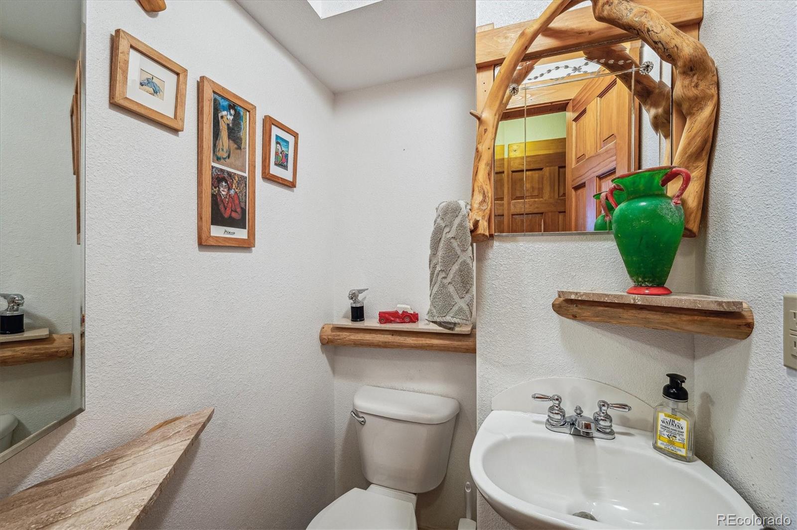 12973 Upper Ridge Road Conifer, CO 80433 - Photo 13 of 46 a bathroom with a toilet sink and mirror