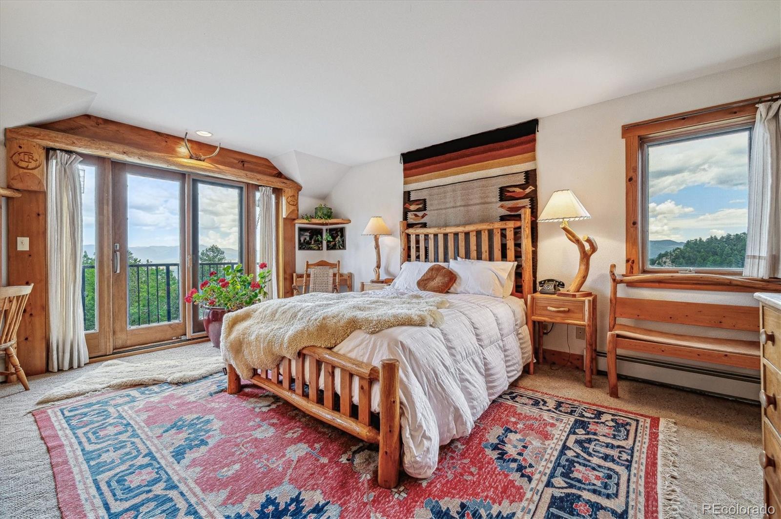 12973 Upper Ridge Road Conifer, CO 80433 - Photo 16 of 46 a bed sitting in a bedroom next to a window