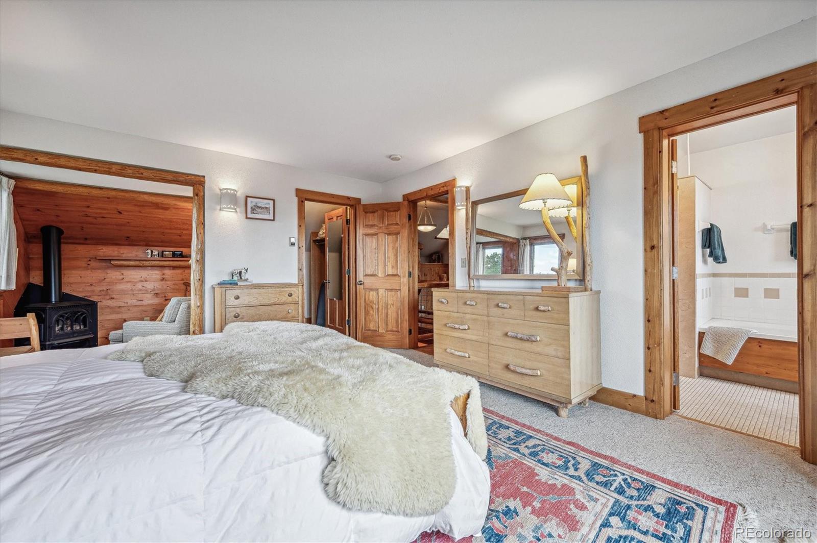 12973 Upper Ridge Road Conifer, CO 80433 - Photo 17 of 46 a bedroom with a bed and a dresser